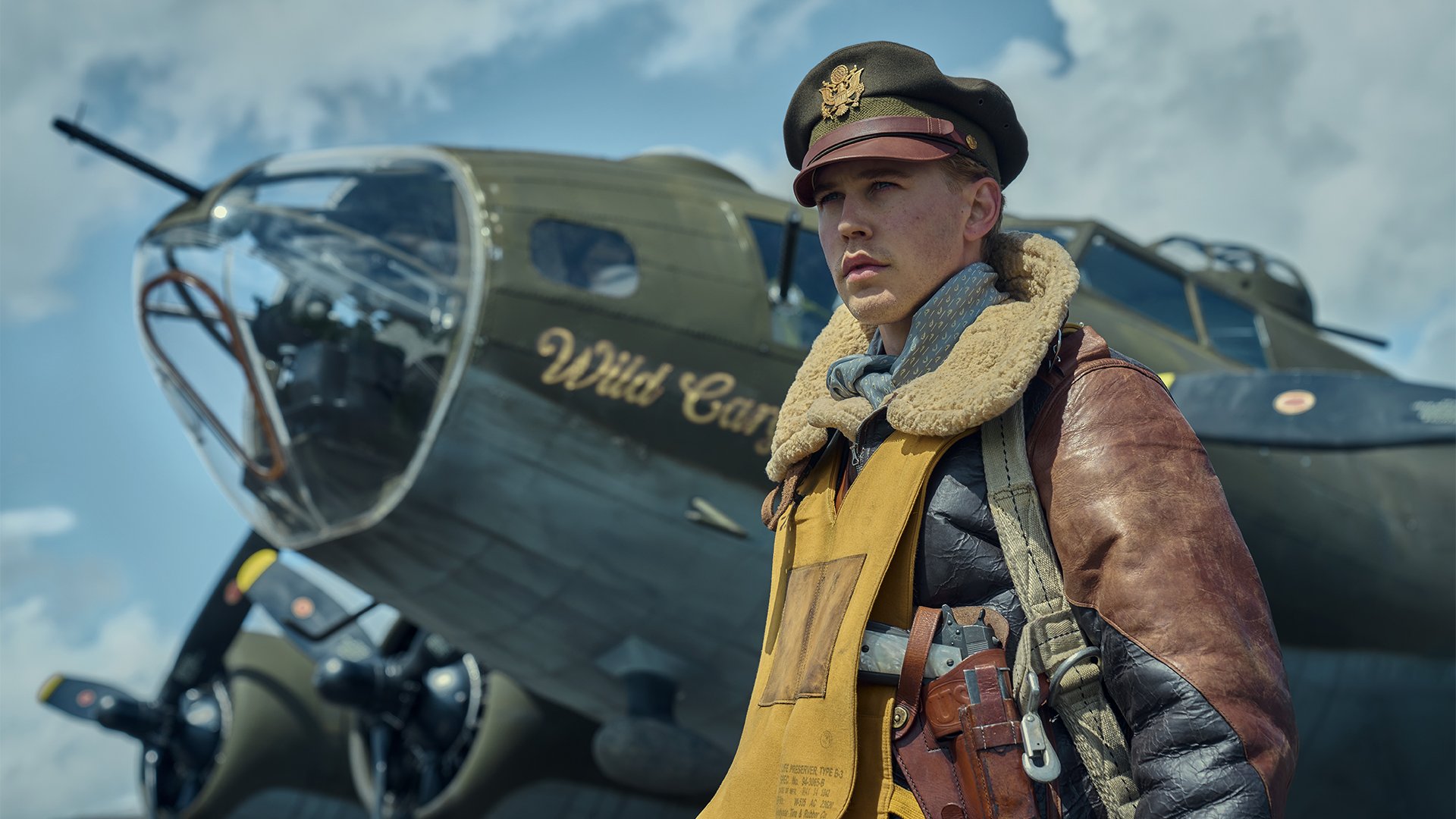 Austin Butler as Gale "Buck" Cleven from Masters of the Air standing in front of a B-17.