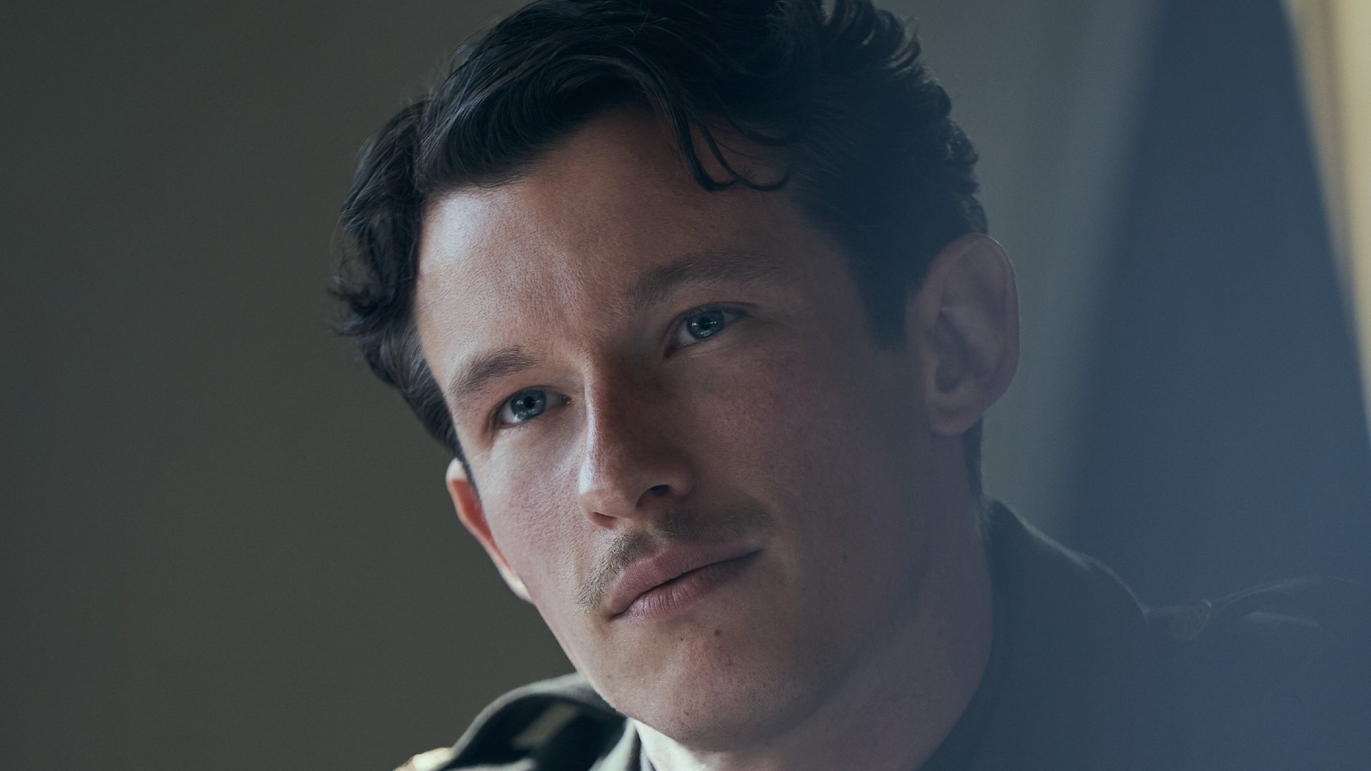 Callum Turner as John "Bucky" Egan staring into the camera.