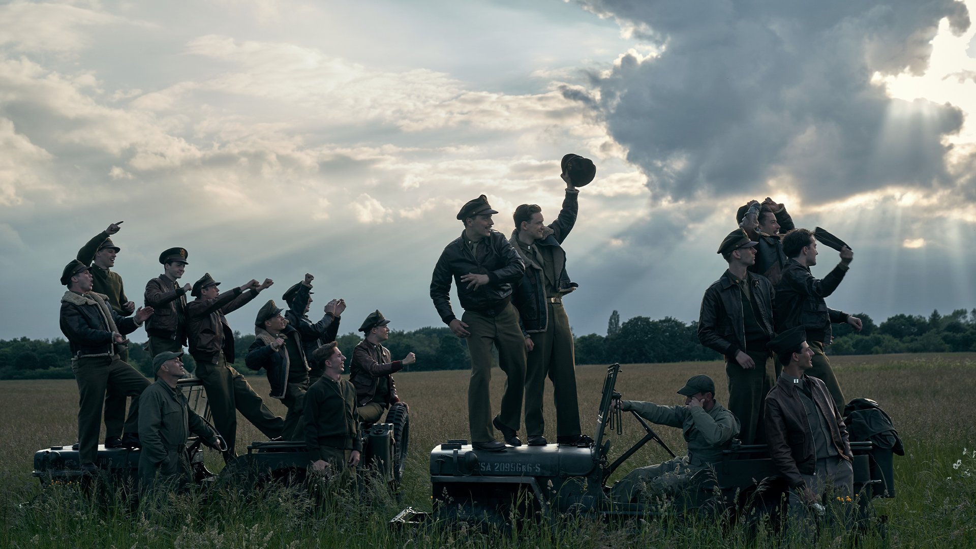 Assembled cast from Masters of the Air celebrate during a scene.