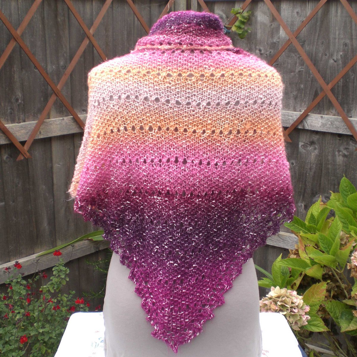 This unique knitted triangle shawl is handmade with a cotton blend yarn in a mix of pink, peach, orange, and crimson colours. It has a lacy panel on every 12th row and along the three edges. Available in my Etsy shop at: barbarakentcrafts.etsy.com/listing/732886… #knittedshawl #etsyhandmade