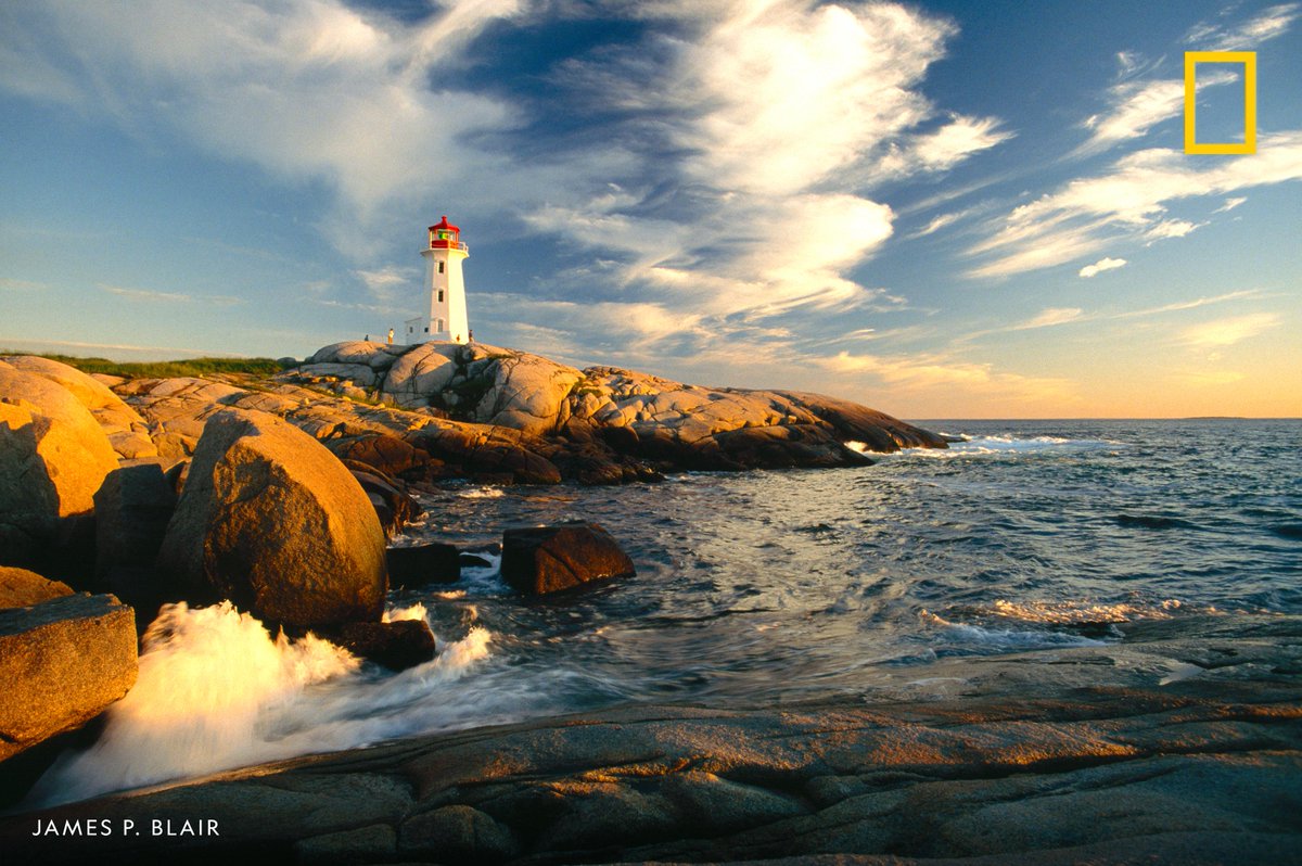 Surf pounds the rocky shore near Peggy's Point Lighthouse, Nova Scotia, Canada.
