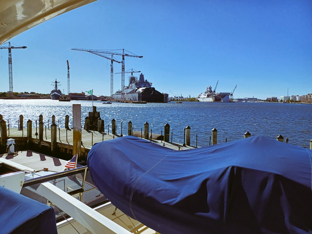 View of Portsmouth from Norfolk Virginia.
Security in the small boat in front of the drydocked warships keeps the straying boaters away.