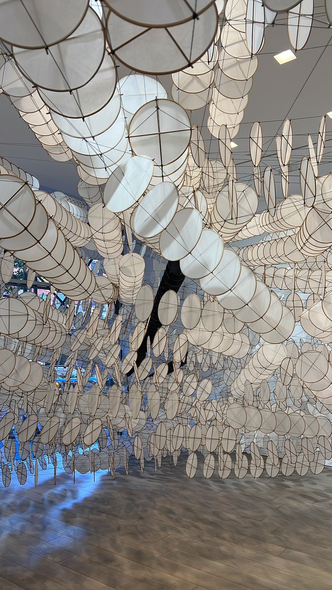 jcrmtxus's tweet photo. The Disappointment Engine, Jacob Hashimoto (USA)
Site specific hanging installation stretching from wall to wall made of bamboo, paper, wood, and cables, 2023. 

“Jacob Hashimoto: The Disappointment Engine”  
#MilesMcEneryGallery #NYC #JacobHashimoto 

Jacob Hashimoto (b.1973) is an American artist based in NYC. He creates complex worlds from a range of modular components, bamboo and paper kites, on layered compositions transporting the viewer to virtual environments with video games references —while remaining deeply rooted in artistic traditions of landscape-based abstraction, modernism, and Japanese handcraft. This suspended wavy form begin with a simple element: a kite. Each element is inspired by Hashimoto’s surroundings, pop culture, and current events. These components are assembled into fields of elaborate architectural installations. His artistic references include the works of Mark Rothko and Helen Frankenthaler, translating the brushstrokes into a repeating module or disk shape, as form of pixels, nodding the artist’s interest in virtual realms, layers, multiplication, and movement around physical space where the viewer is surrounded and almost embraced by his creation. 

#art #artinstallation #contemporaryart