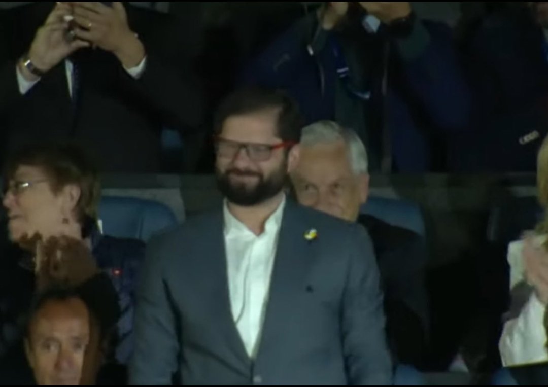 Yuyodelizqui's tweet photo. La cara de Piñera atrás mientras el Estadio Nacional ovaciona a Boric #Panamericanos 
#Panamericanos2023 https://t.co/rvF7DIs6AQ