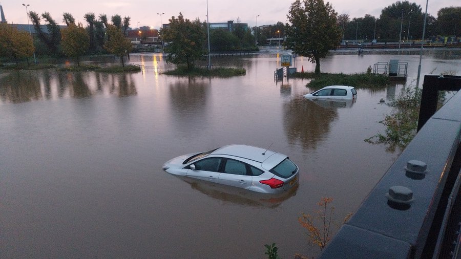 two cars submerged under water on a car park