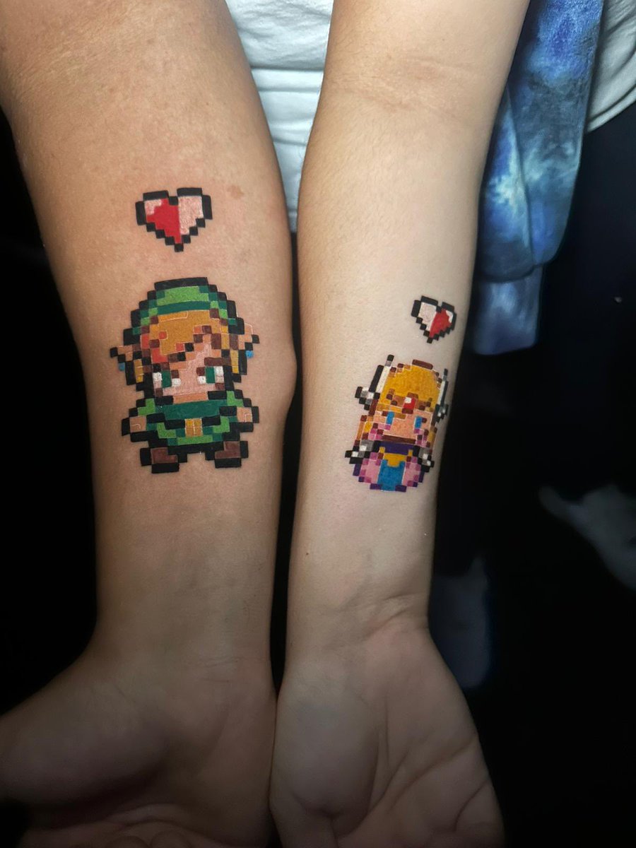 TheGameShower's tweet photo. I have the best wife ever! She actually agreed to get this matching tattoo with me and I couldn’t be more happy! Been wanting a Zelda related tattoo for a while and finally got it! Pixilated Link &amp; Zelda 🎮😆 https://t.co/pJ9isgaOzU