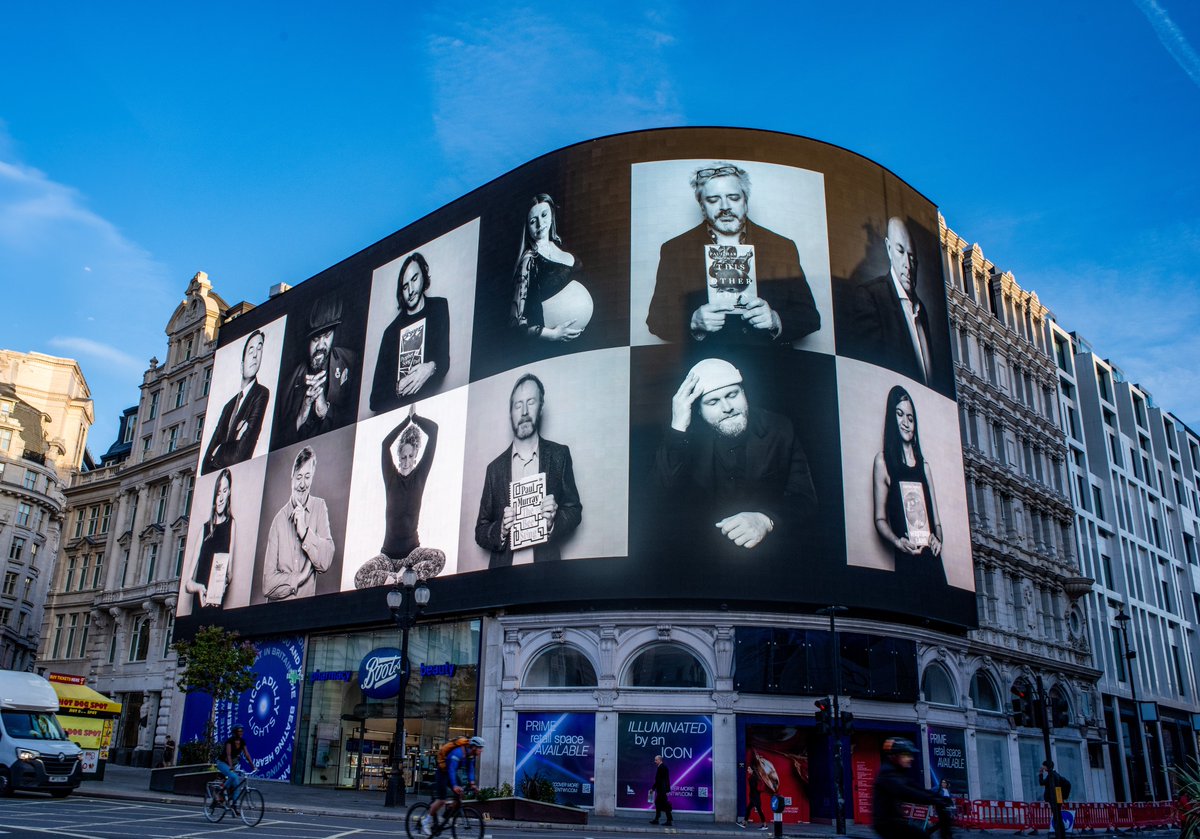 Booker Prize finalists on digital billboard in Piccadilly Circus, London.  (Paul Harding top front and center, on the curve, holding THIS OTHER EDEN.) When will <a href="/nationalbook/">National Book Foundation</a> make an arrangement to put their finalists up in Times Square?