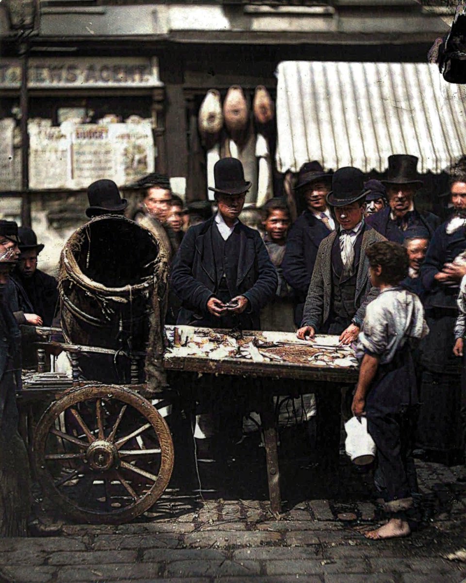 Costermonger Joseph Carney sells fresh herring from his barrow in the street market between Seven Dials and Five Dials in London, 1877. #victorians #fishmarket #costermonger #streetmarket #market #sevendials #fivedials