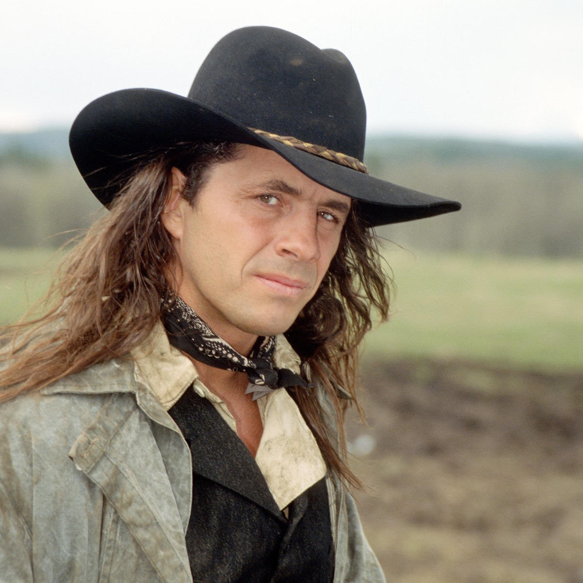 FightPromoting's tweet image. Bret the Hitman Hart wearing a black cowboy hat, neckerchief, and denim shirt over some other shirts