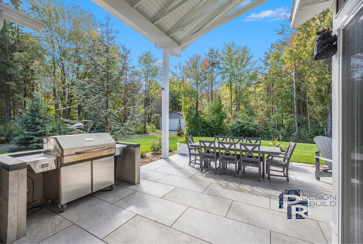 PRDesignBuild's tweet photo. Introducing our latest project reveal - a stunning covered porch, a cozy 3-season room with a double-sided fireplace, a patio with porcelain pavers, and a fully equipped outdoor kitchen. 
Explore more at https://t.co/0MJYWVd4ns. #PRDesignBuild #HollandMI #LuxuryLiving https://t.co/kjFMBBCqO3