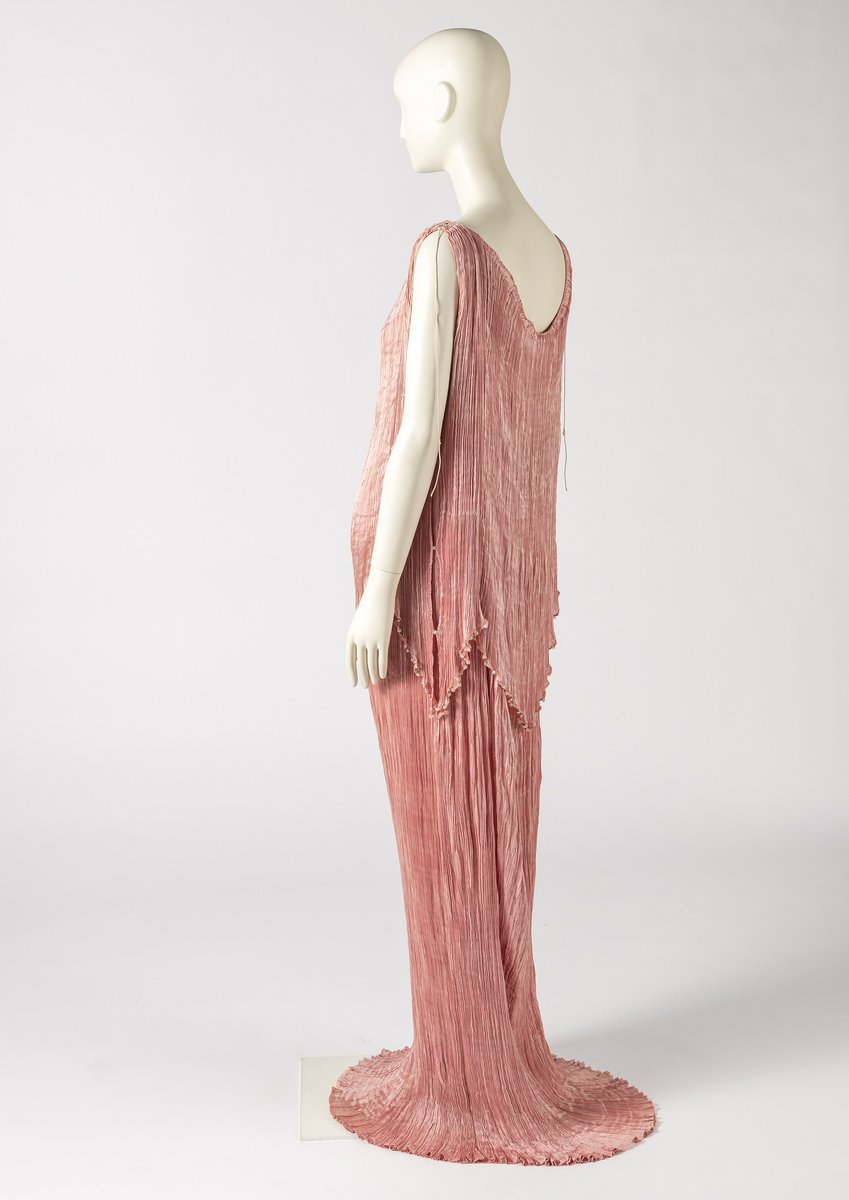 Friday Treat Time and a light pink pleated silk satin evening dress from the 1920s. This stunning Peplos design by Venice-based fashion house #Fortuny is a variation on its iconic Delphos gown, inspired by and named after the classical Greek statue, The Charioteer of Delphi 🩷