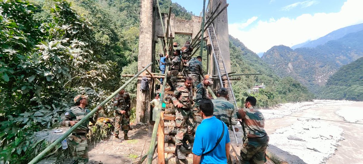 trishakticorps's tweet photo. Troops of #TrishaktiCorps along with Rural Development Authority & locals constructed a Foot Suspension Bridge of 300 ft length adjacent to Mangan - Sanklang Bailey bridge . An aerial cable 320 ft in length has also been prepared over Teesta River. These have enabled evacuation of tourists and locals from North #Sikkim & ferrying of relief materials.

#sikkimfloods
 #sikkimflashfloods 
#IndianArmy 
#WeCare 
#HarKaamDeshKeNaam

 @PSTamangGolay 
@HQ_IDS_India 
@SpokespersonMoD 
@adgpi 
@easterncomd 
@PIB_India 
@PIBGangtok 
@DDNewslive 
@aajtak 
@the_hindu 
@airnewsalerts 
@CNNnews18 
@WIONews 
@SikkimExpress 
@SikkimChronicle 
@sikkimgovt