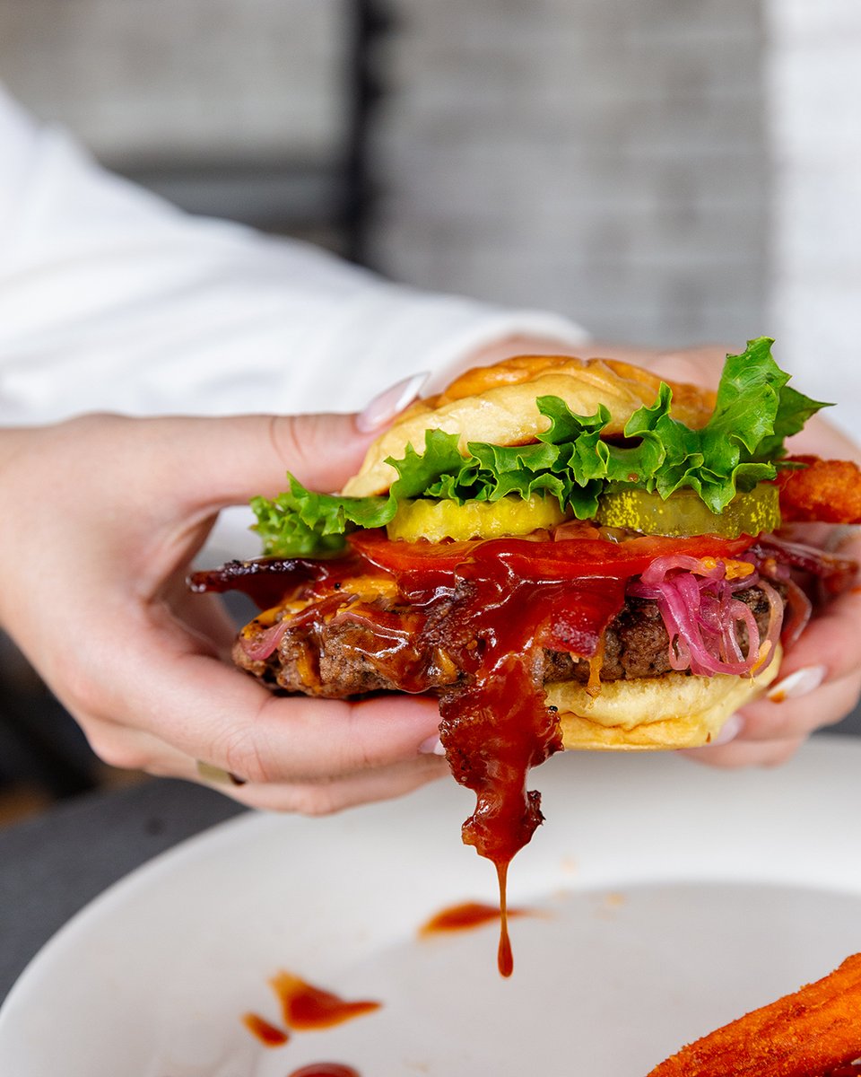 You better get a napkin or twelve! Try the Pedigree Burger from Lucky's. This special burger is topped with BBQ sauce, shredded cheddar cheese and Applewood smoked bacon!