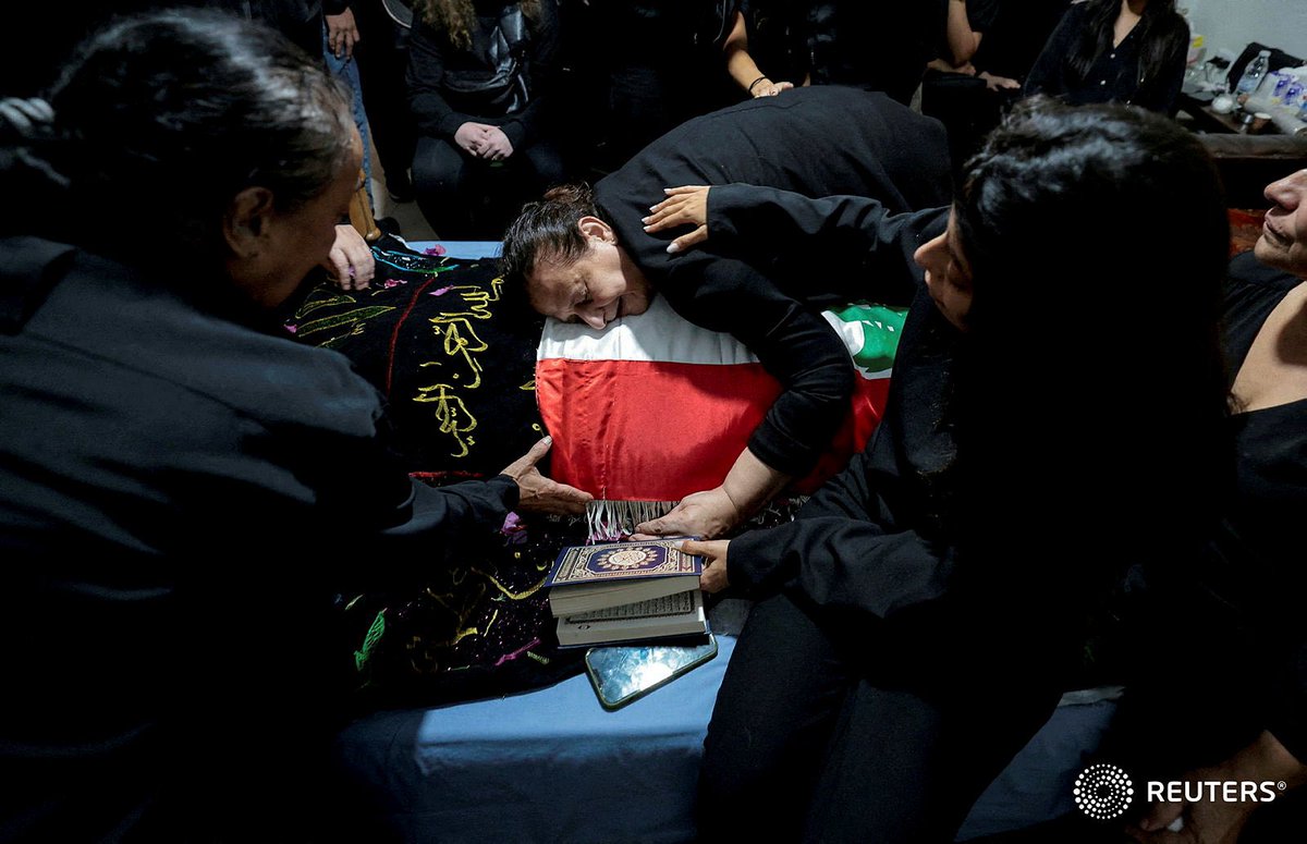 Fatma Kanso, mother of Issam Abdallah, a Lebanese national and Reuters videojournalist who was killed in southern Lebanon by shelling from the direction of Israel, mourns over her son's body during his funeral in his home town of Al Khiyam, Lebanon REUTERS/Zohra Bensemra