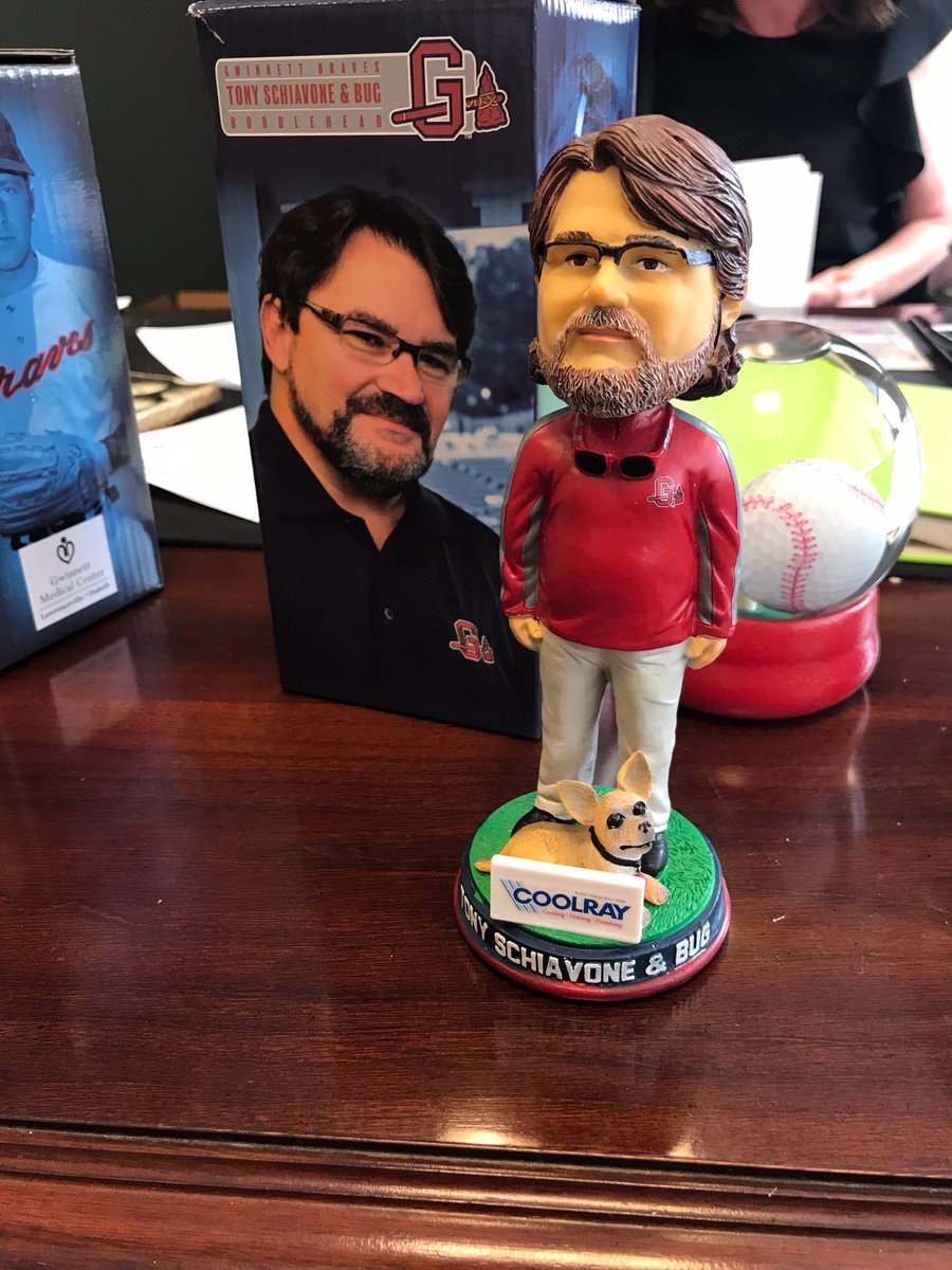 FightPromoting's tweet image. Tony Schiavone wearing a red Gwinnett Braves shirt with gray slacks and the “yo quiero Taco Bell” dog