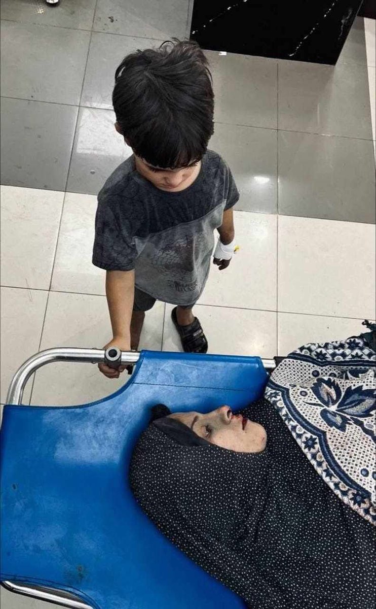 A Palestinian child paying farewell to his mom killed by Israeli airstrikes. #GazaGenocide