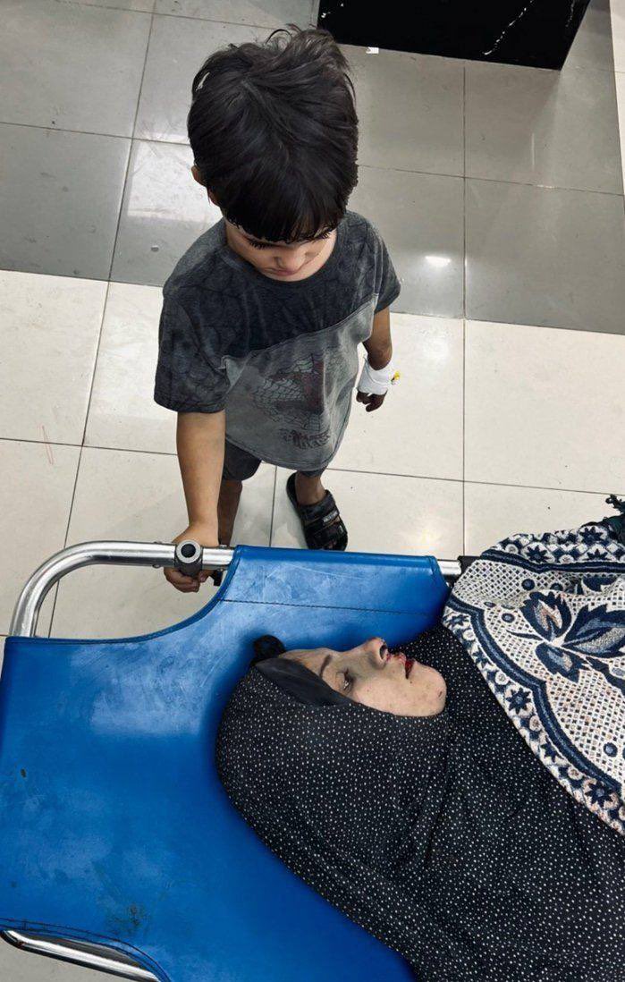 AlQastalps's tweet photo. A circulating picture of a wounded child looking -for the last time- at his mother, who was martyred as a result of the #Israeli aggression on #Gaza. https://t.co/F2UbxfPEmG