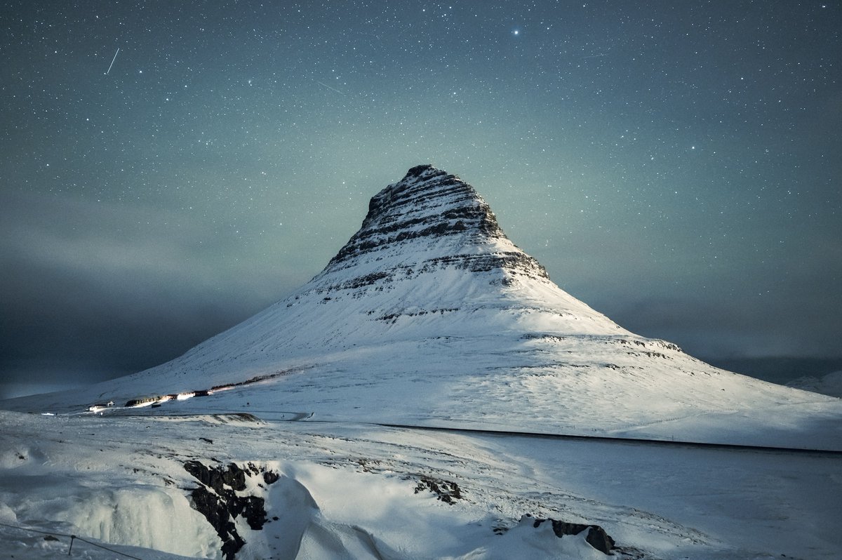 Under a blanket of stars, the majestic Kirkjufell of Iceland stand tall, inviting you to witness nature's grandeur. Come, let the serene landscapes envelop you in a world of wonder. ✨🏔️