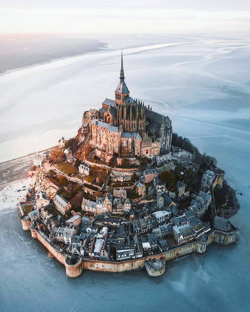 archi_tradition's tweet photo. Mont Saint-Michel, France 🇫🇷 

Situated on a rocky islet off Normandy's coast, Mont Saint-Michel boasts a remarkable history spanning over a millennium. Its story begins in the 8th century when Bishop Aubert of Avranches claimed divine inspiration to construct a hermitage on the site. This hermitage evolved into a grand abbey, drawing pilgrims and scholars during the Middle Ages, with a village forming at its base.

The most intriguing aspect of Mont Saint-Michel is its tidal surroundings. The island is surrounded by the largest tides in Europe, with water levels varying dramatically between high and low tides. The most extreme range being 14 meters (45 feet)! This natural phenomenon has made access to the island challenging, leading to the construction of a causeway. The tides also contributed to its defense, turning it into an impregnable fortress during the Hundred Years' War.

Additionally, Mont-Saint-Michel is known for its salt lamb, a local delicacy. These sheep graze on the surrounding salt marshes, giving their meat a unique flavor. Today, this UNESCO World Heritage site continues to captivate visitors with its history, architecture, and the wonder of the tides.

📸: Marcel Siebert | IG