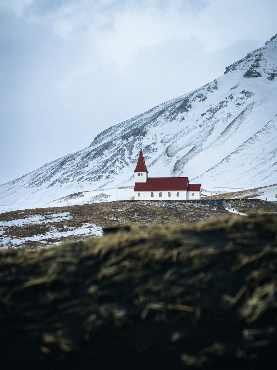 Amidst the vastness of Iceland's landscapes, a beacon of warmth and hope stands tall. This little church, nestled against snow-clad mountains, reminds us of the beauty found in simplicity and serenity. 🏔️❤️🕍