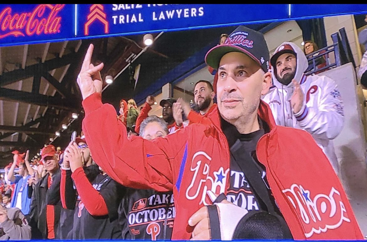 KeeleyFox29's tweet photo. At @phillies game tonight.   Wounded @PhillyPolice Officer Raul Ortiz,60, showing his Championship ring finger Nick Castellonas style.   He was shot in the arm, now bandaged in sling under his Phillies jacket. https://t.co/jBRpKiyT0z