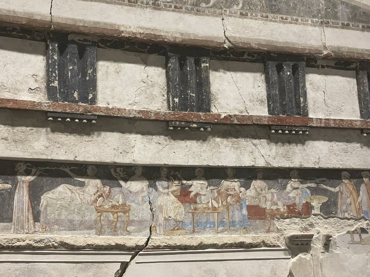Carolyn_on_X's tweet photo. Macedonian tomb, Aghios Athanasios. The frieze has a symposium scene flanked by men approaching from left &amp; right, some in military dress. 

Below two mourning men in Macedonian military garb, shields behind, guard the entrance. Dated to the last quarter of 4thC BC. #TombTuesday https://t.co/rsD28IHrT6