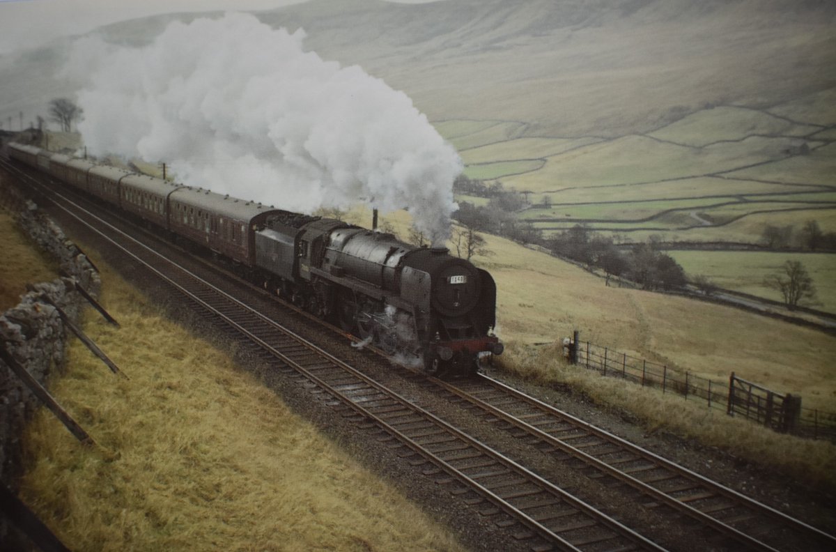 Britannia 70003 'John Bunyan' is seen on the climb to Ais Gill at Mallerstang Common with a train bound for #Carmarthen. This was a  special in connection with a #Scotland vs #WALES Rugby Union International at #EDINBURGH 
Date: February 1967
📷 Photo by Peter Fitton.