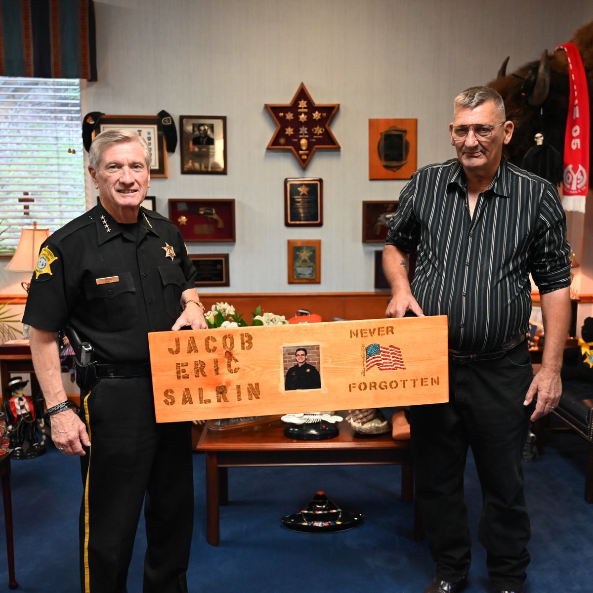 RCSD's tweet photo. Mr. Brett Thomas presented Sheriff Lott and the Richland County Sheriff's Department with a wooden bench he made in memory of our fallen Deputy Salrin. We are thankful for this thoughtful gift! https://t.co/FjV5LuyCFv