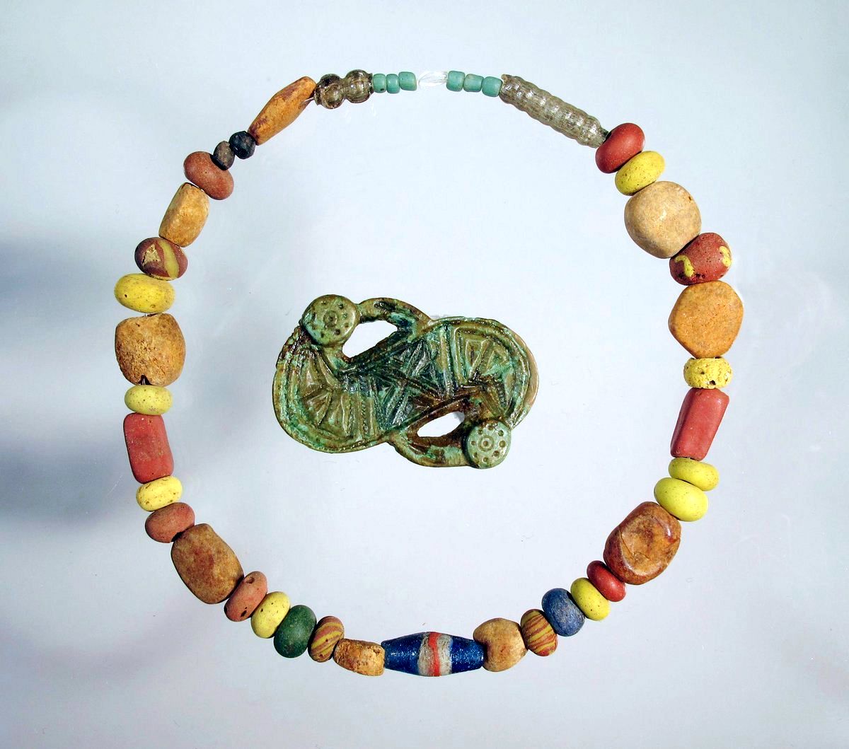 DrNWillburger's tweet image. Some 1,500 years ago, a 6-month-old girl was buried with a necklace and a S-shaped fibula (a pin for fastening garments) in Aschheim, Bavaria. The beads of the necklace were made of glass and amber. Both the necklace and the fibula were to large for the little girl. 1/2