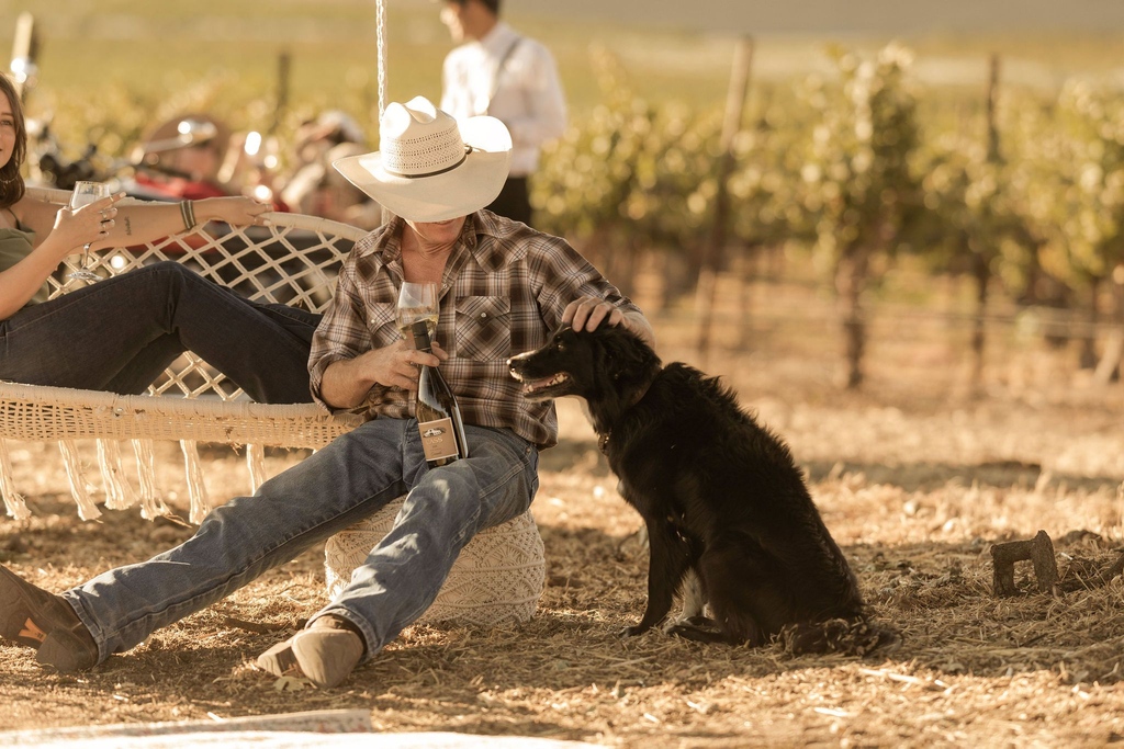 Celebrating #WineWednesday in true Paso style with a cowboy hat, a glass half-full and a vineyard dog. 🤠⁠
⁠
Captured by @molly.v_⁠
⁠
#TravelPaso #SLOCAL⁠ #PasoWine #WineWednesday
