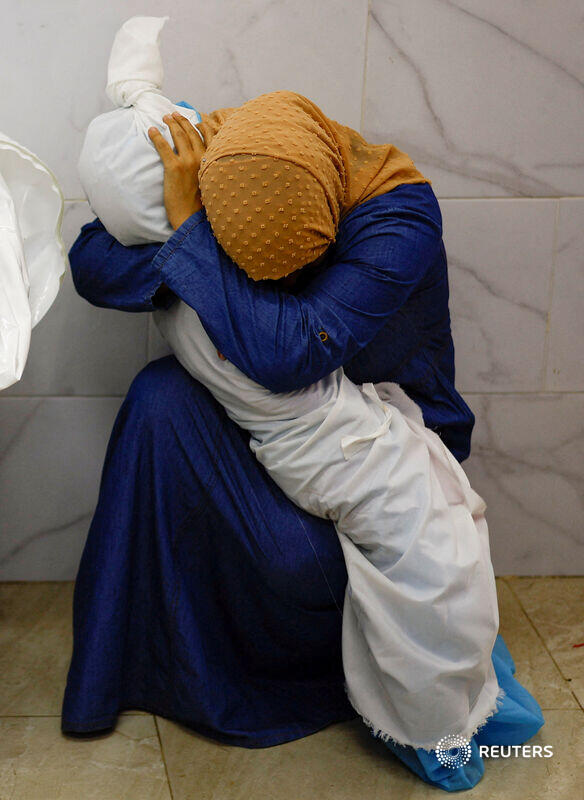 A woman embraces the body of a Palestinian child killed in Israeli strikes at a hospital in Khan Younis in the southern Gaza Strip reut.rs/45HSbDP 📷 Mohammed Salem
