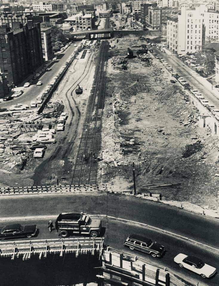 This view, taken from the Transit Building in May 1963, looks west over the temporary Massachusetts Avenue detour and over the swath of cleared land that will soon be graded and paved to form the Mass Turnpike roadway. ( David Milliken)
