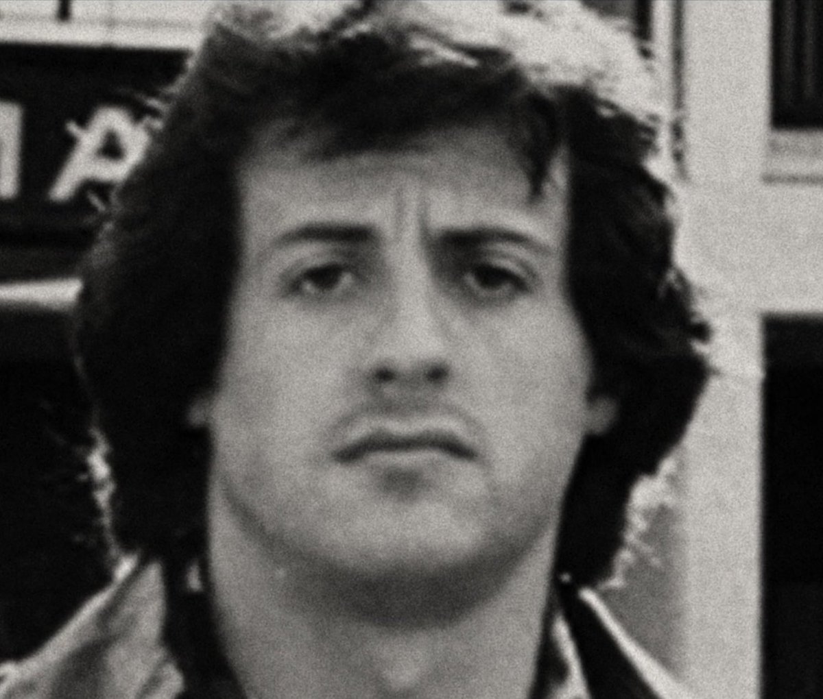 Cette photo apparemment banale de Sylvester Stallone a une histoire particulière. 
Elle a été prise à Los Angeles le 19 novembre 1976 lors de l’avant première officielle du film ROCKY qui doit sortir sur les écrans US le lendemain. 
Le public venu nombreux est dans la salle.