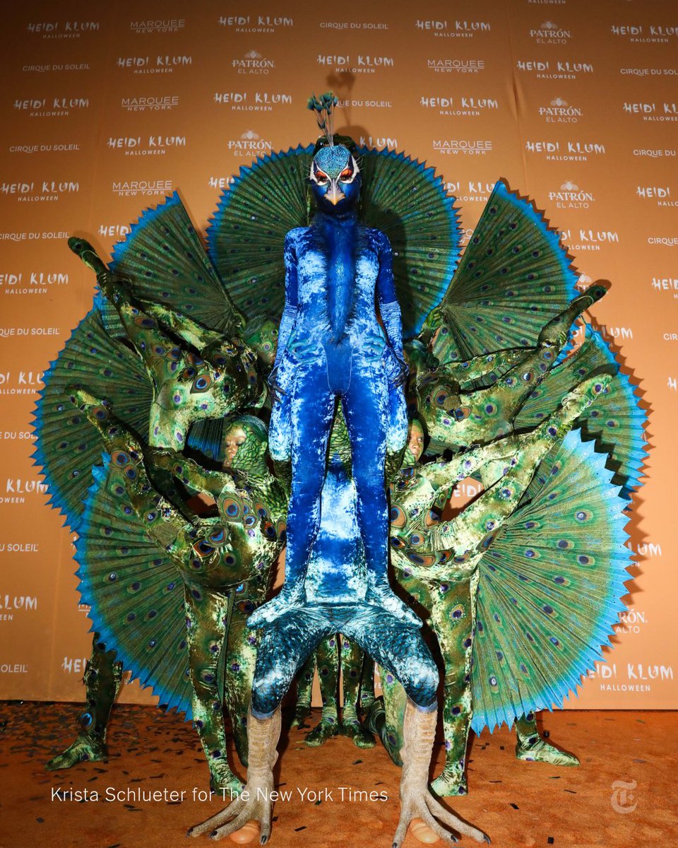 Heidi Klum dressed as a giant peacock with some help from Cirque du Soleil performers at her annual Halloween party in New York City. nyti.ms/3Mr2961