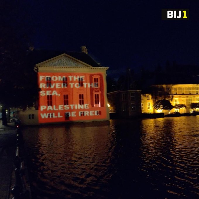 Foto van het Mauritshuis 's avonds. Op het gebouw staat geprojecteerd 'From the river to the sea, Palestine will be free'.