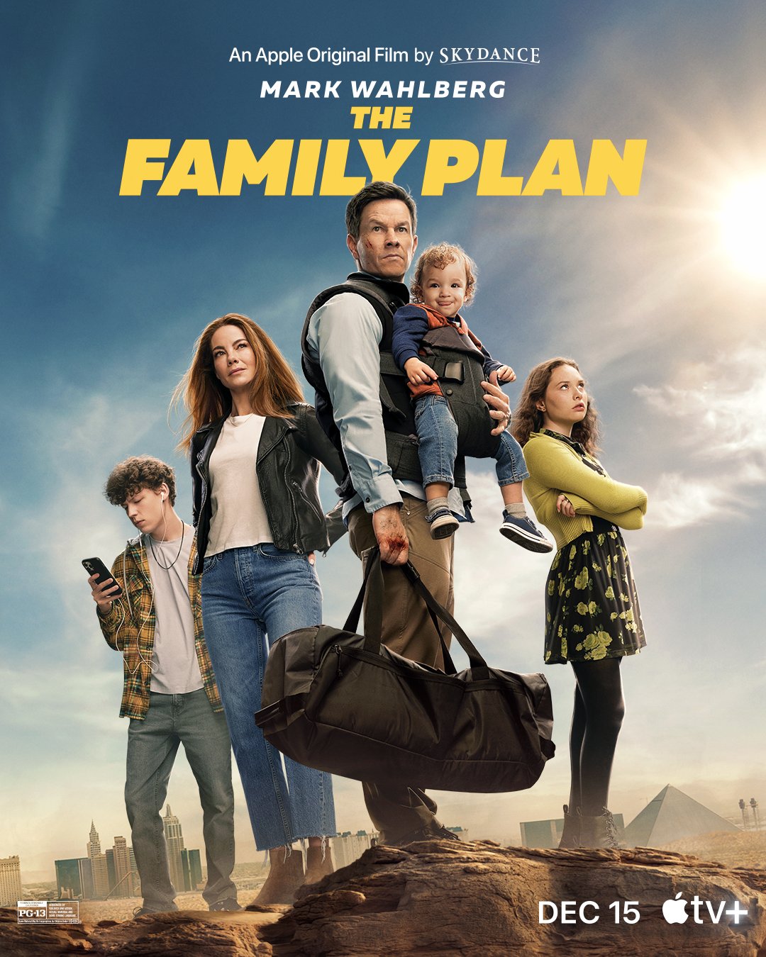 Mark Wahlberg (Dan Morgan) from The Family Plan stands in the forefront with a defiant expression, holding a child strapped to his chest in a baby Bjorn with one hand, and a duffel bag in the other. The baby (Max Morgan) is poking it's tongue out. Michelle Monaghan (Jess Morgan) stands behind him to his left, looking up to the right with her hair blowing in the wind. To the right is Zoe Margaret Colletti (Nina Morgan), looking up in frustration with her arms crossed. On the far left, behind Michelle Monaghan is Van Crosby (Kyle Morgan), with white headphones in his ears and looking down at a phone. The backdrop is a desert with Las Vegas landmarks scattered in the background.