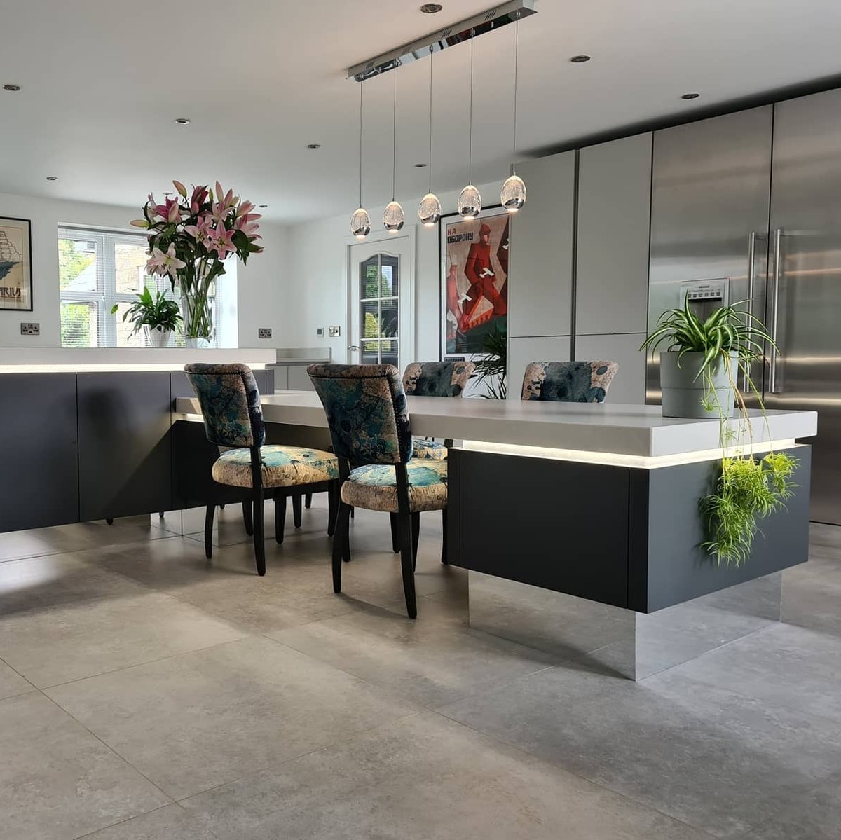 A breathtaking space using sharp shaping and deft contrasting to create evoke an atmosphere that is undeniably unique. Throw in some botanical and lighting features, and you're left with an all time great Masterclass Kitchen.⁠ .⁠ 📸 H Line Sutton Graphite and Light Grey⁠