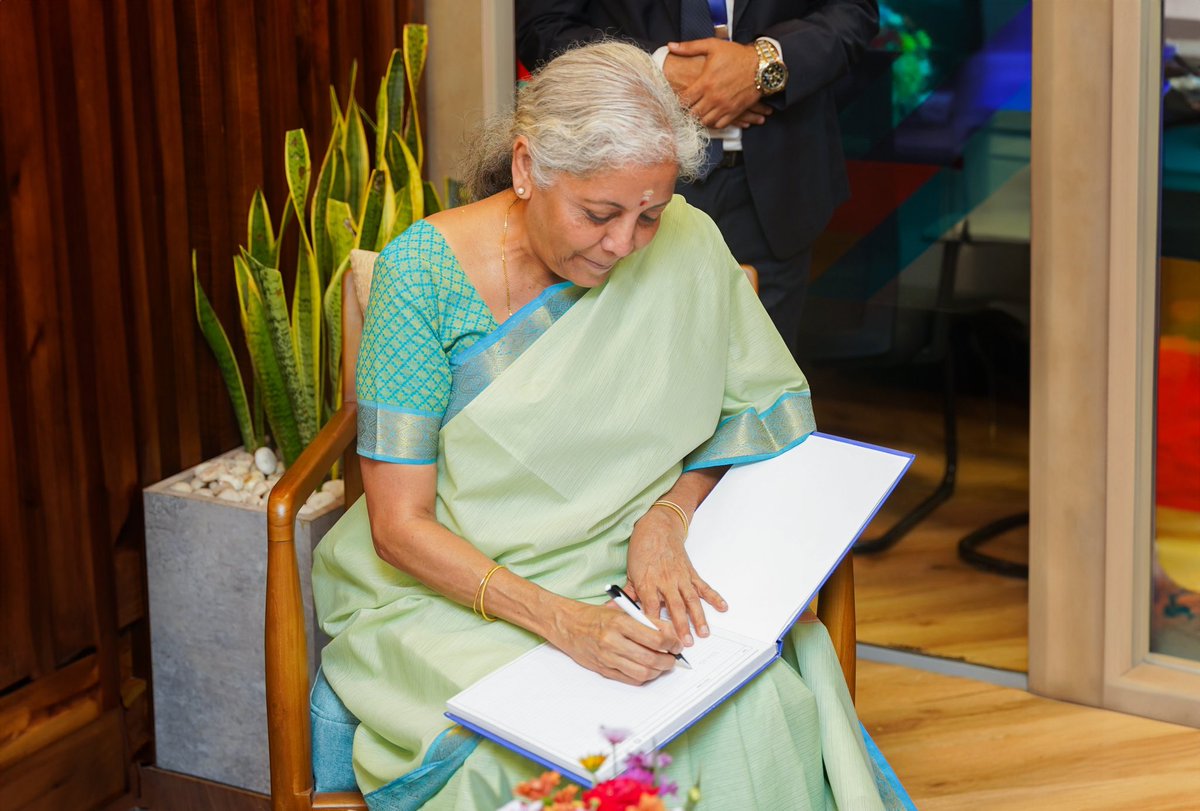 FinMinIndia's tweet photo. After the inauguration, FM. Smt. @nsitharaman interacted with the new branch officials and distributed passbooks to new customers, besides filling the visitor’s book in Trincomalee, Sri Lanka. (2/2) https://t.co/QN8lhYqpsi