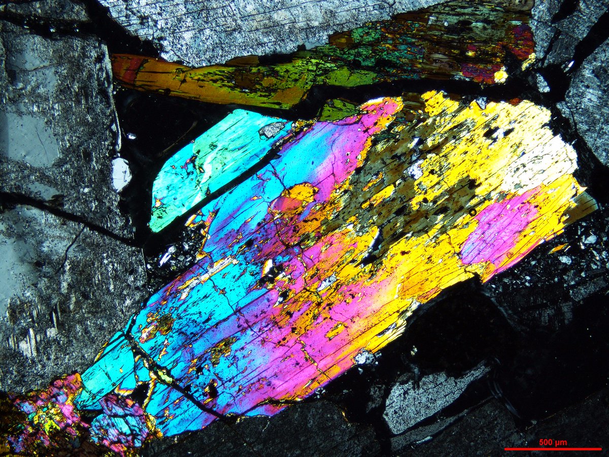 Agpaitic_Adam's tweet photo. My favourite and most spectacular aegirine crystal, complete with a relict Na-amphibole 'core', and framed by anorthoclase. There might be a smidge of eudialyte hiding in the dark in there too. 

#thinsectionthursday #geology #petrology #rocks #Microscopy #volcanology https://t.co/guCHldzAL0