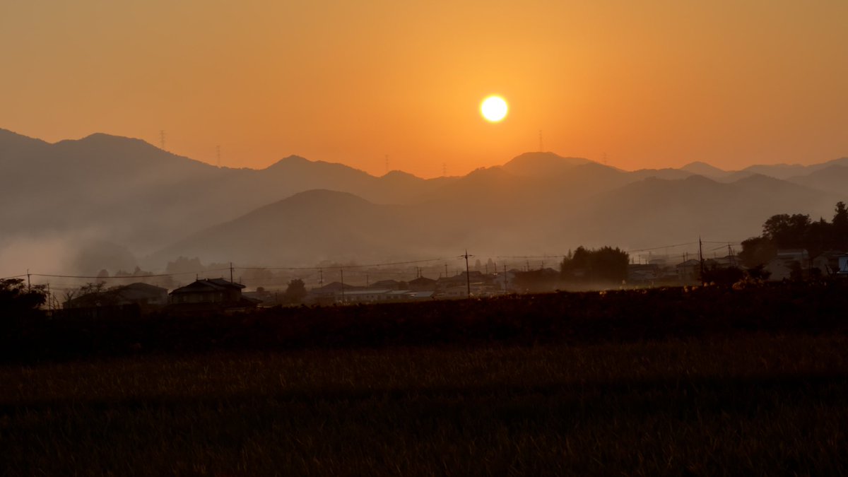 The golden sky and smoke around the valley hills are usually seen in the remote village of Tambasasayama on an autumn evening.