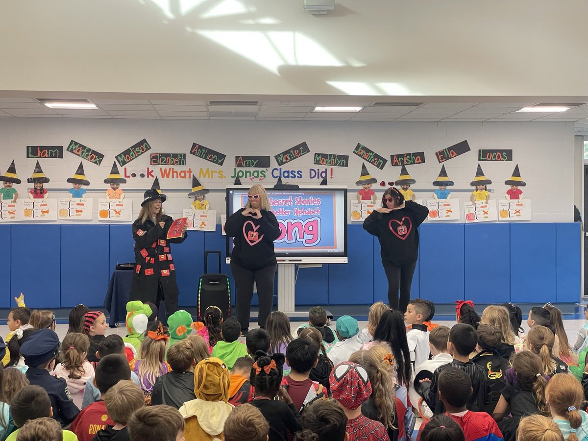 SlocumCSD's tweet photo. Mrs. Dluginski kicked off Halloween with a K-2 assembly about the Secret Stories! She had a little help from Slocum faculty and staff. Grades K-2 finished the assembly by singing The Secret Stories Better Alphabet Song that they have all been practicing in class! #SlocumShines https://t.co/sy1FClGLRm