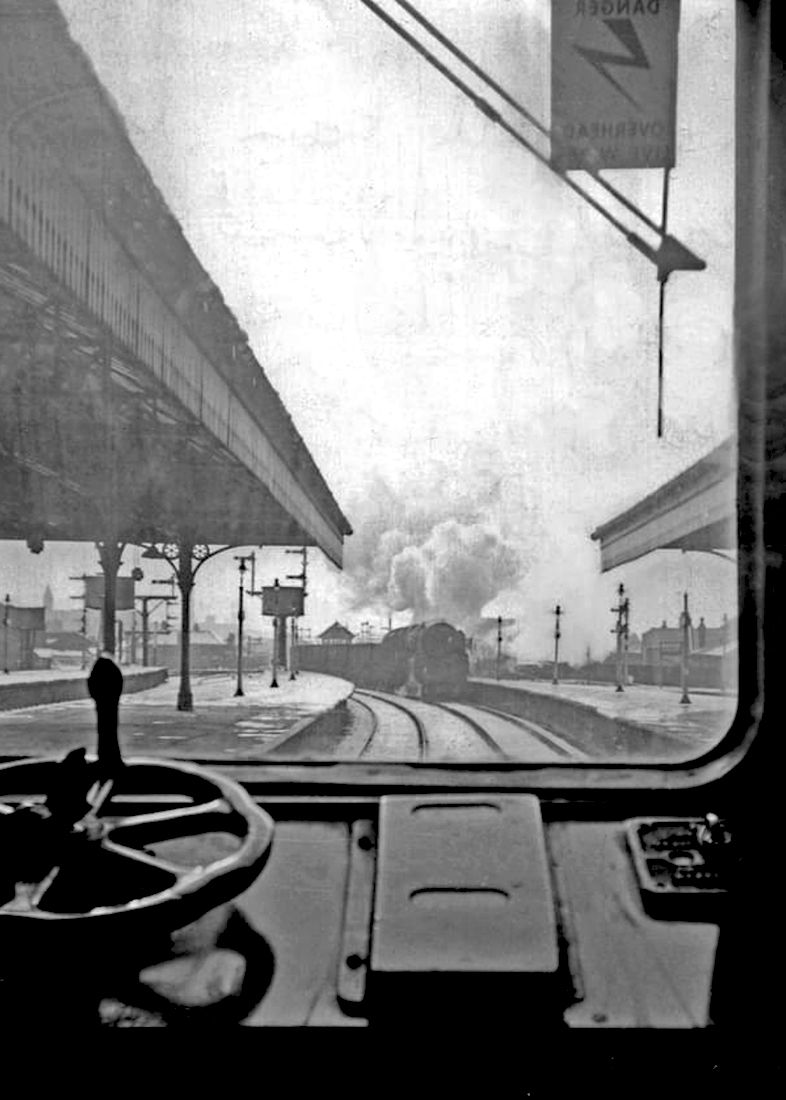NowtbutaLad's tweet photo. View through the cab window of a Cravens DMU at #Blackburn station, with Class 9F 92017 approaching with a goods train up to Hellifield and the Long Meg Sidings on the Settle-Carlisle line, Winter 1964 [pic. Tony Mercer]. @railnigel #Railways #Lancashire https://t.co/K2zYm1D47t