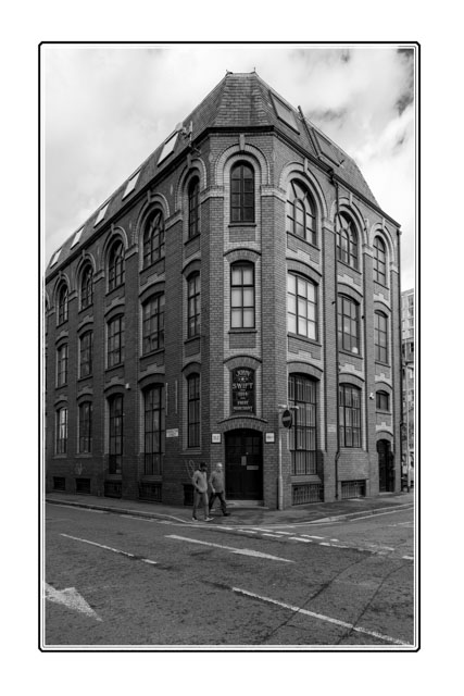 Two men walking past one of the older buildings in the #NorthernQuarter @NQManchester #Manchester. This #historic #building was used by a #fruit #merchant until being used as #offices and #smallbusinessowners. #blackandwhitephotography #architecuralphotography #PhotographyIsArt