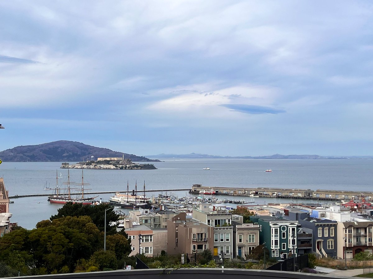 BalloonSciDan's tweet photo. A dark little lenticular cloud rides the crest of Alcatraz Island's gravity wave today.  The wind coming into the bay from the west (left) is bounced up by hitting the prison island. It's highest is downwind where some vapor condenses and then evaporates as it bounces back down. https://t.co/ZHD7GYondM