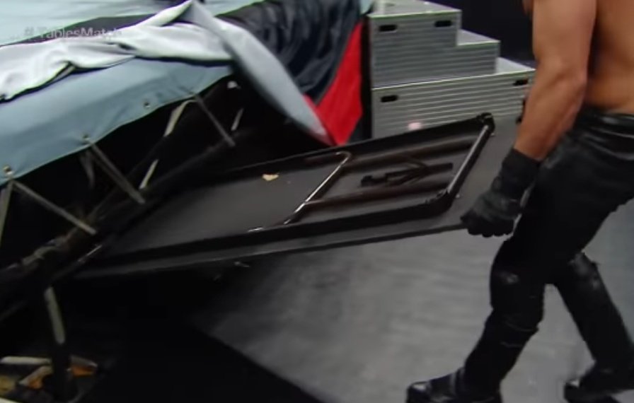 Devitt_Rimmer's tweet photo. As #DevittRimmer marches towards the structure slowly... measuring the situation for the battle going inside it... He flips open the ringside cover... And takes out TWO TABLES out of it! Crowd goes nuts!!!! 

He beats the cage from outside to call his comrades and here are the https://t.co/CV5iBwiiR3