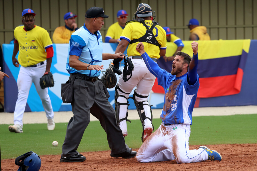 Jugador brasileño celebra de rodillas frente al árbitro y con los jugadores colombianos caminando de fondo
