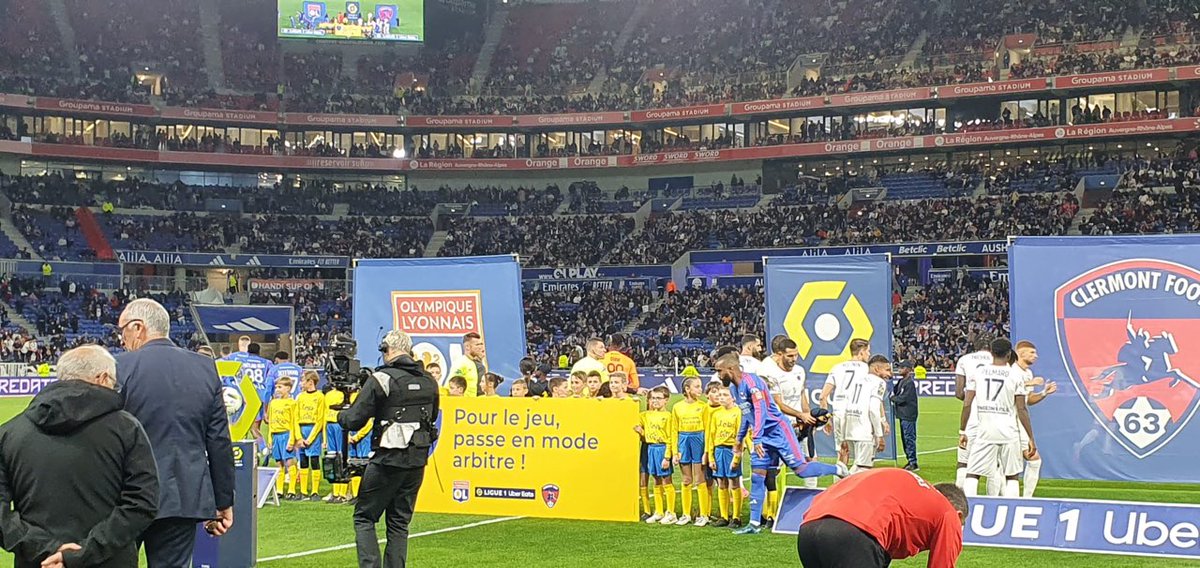LPNews_AURA's tweet photo. A l'occasion des Journées Nationales de l'Arbitrage, 2️⃣3️⃣ enfants de #postiers accompagnent ce soir les joueurs et les arbitres pour le match @OL @ClermontFoot 
Les enfants sont fiers de porter leur maillot #TousArbitres et de soutenir avec #LaPoste les valeurs de l'arbitrage 💛 https://t.co/juPxELibkT