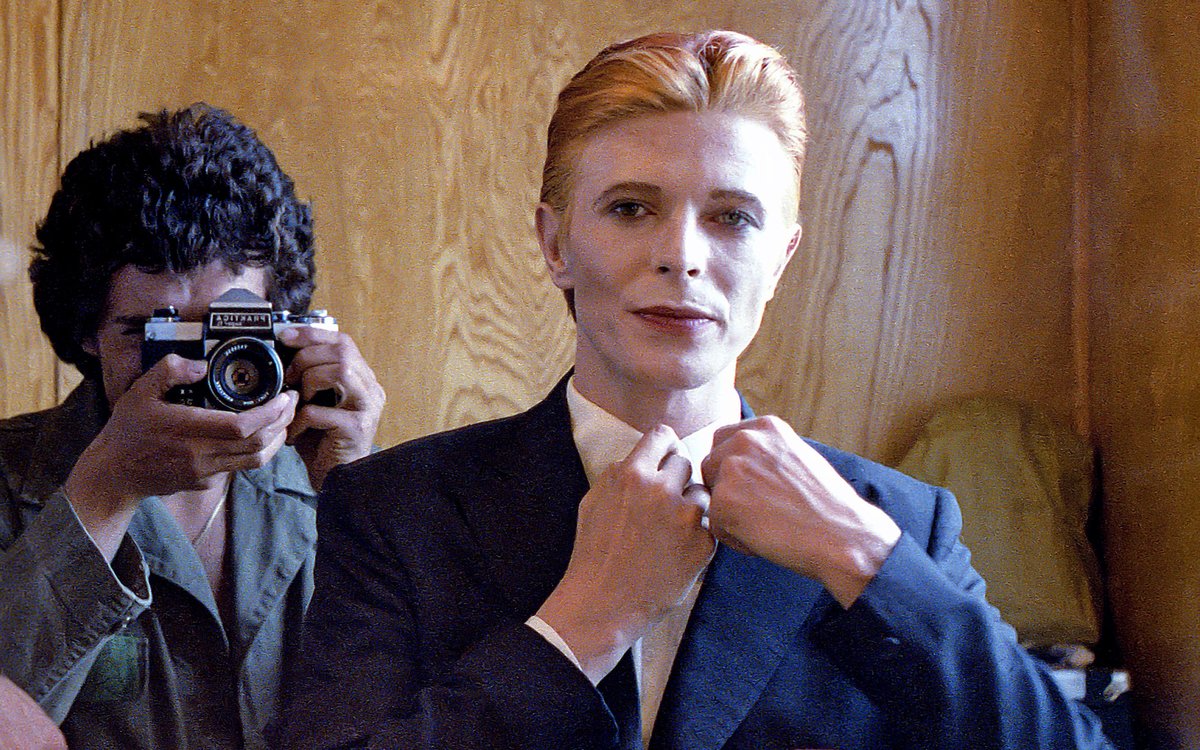 Not much evidence of a mirror in this first shot from 1975 of Bowie as Thomas Jerome Newton, until you look at those famous eyes.

All is revealed in the uncropped image as Geoff MacCormack is seen taking the shot in David’s changing room on the set of The Man Who Fell To Earth.