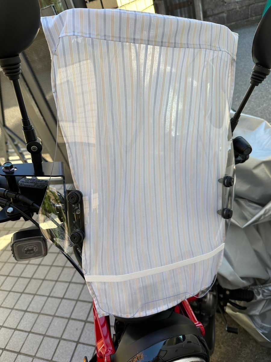 NobiCam_'s tweet photo. デイトナ製スクリーンを外すつもりはありません。デザインが秀逸でツーリング時の風当たりによる疲れ軽減に貢献してくれると信じています。という事で対策を検討。写真は試作ですが停車時にスクリーンをカバーで覆うようにします。薄い布で作っているので嵩張る事もありません。
#ハンターカブ https://t.co/oTLhgBIog1