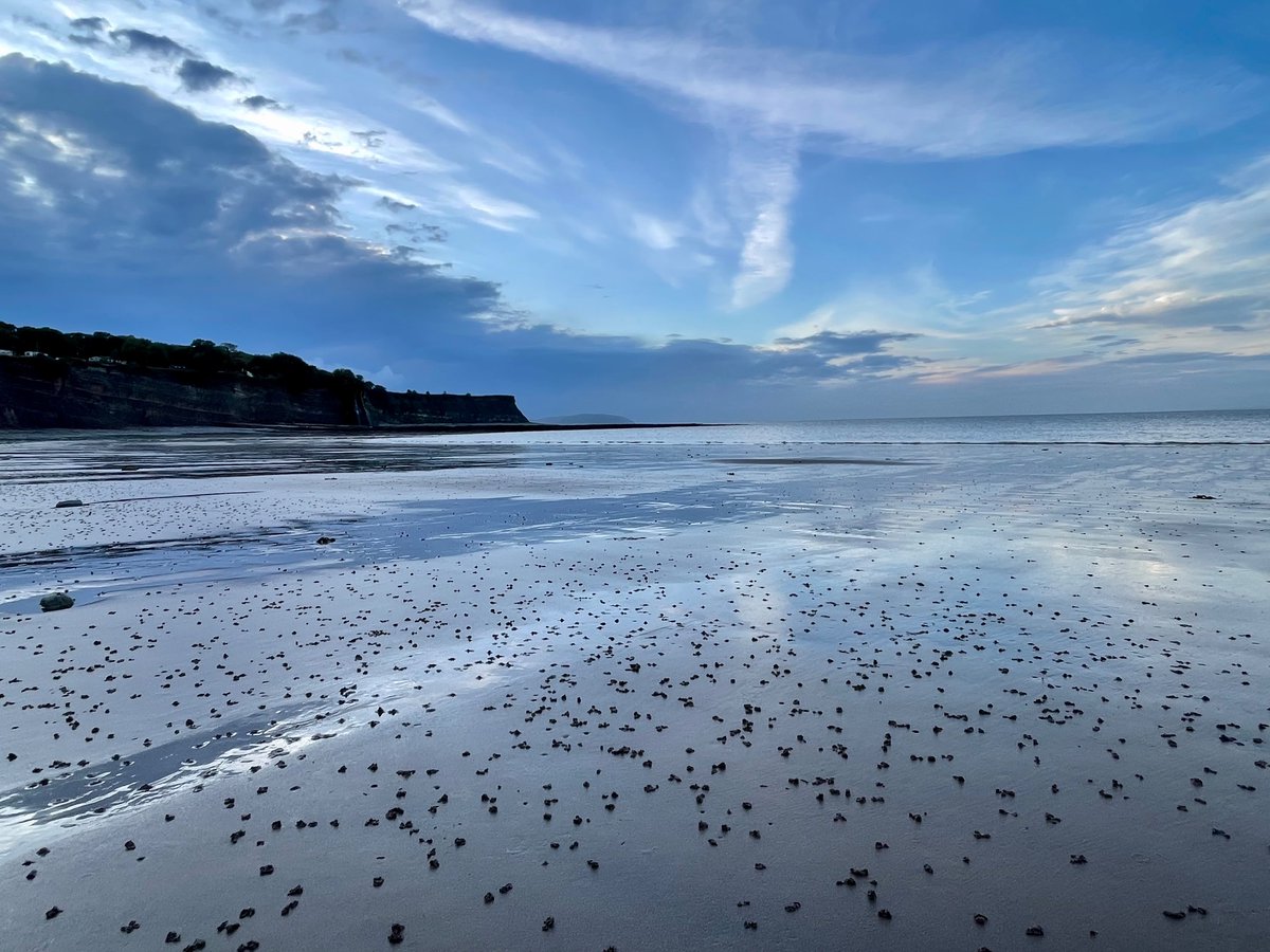Deserted beach with the tide and hills in the background.